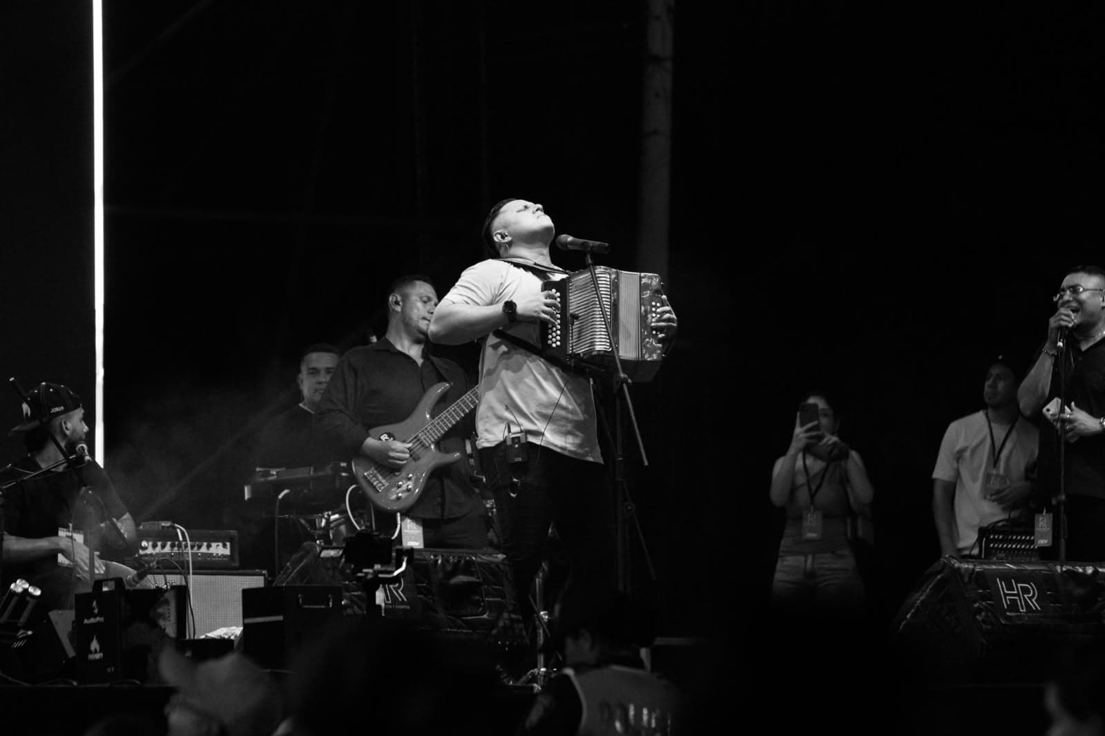 Ralphy Reguillo cantando frente al micrófono en blanco y negro